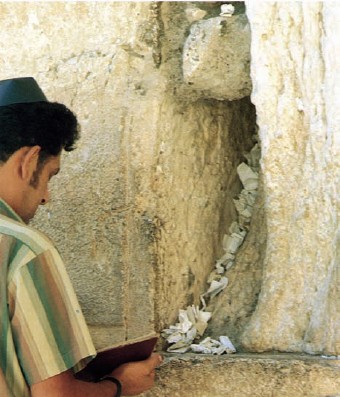 Homme priant au Mur des Lamentations. Les papiers entre les pierres comportent des prières. Photo DR.